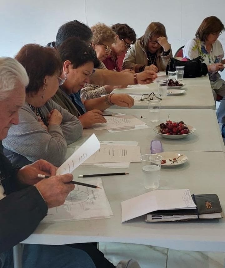Participantes en mesa larga escribiendo en taller grupal