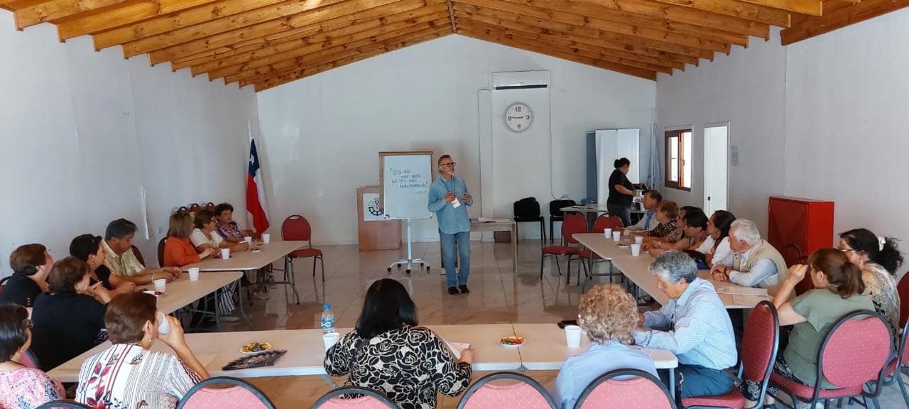 Sala de taller en forma de U con participantes adultos mayores